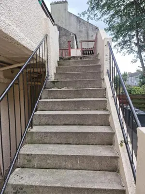 a set of stairs leading up to a building at Cove Bay 1 Bed Flat in Largs