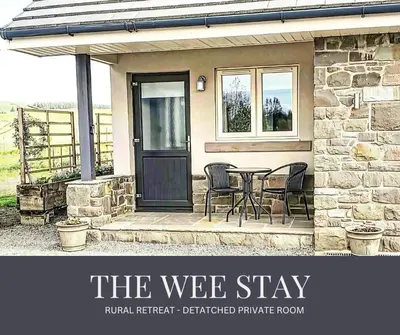 a house with a black door and a table and chairs at The Wee Stay - Room Only - Rural 1 Bed Guest Suite in Middleton Fossoway