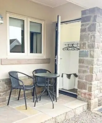 a patio with a table and chairs next to a window at The Wee Stay - Room Only - Rural 1 Bed Guest Suite in Middleton Fossoway