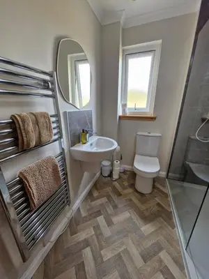 a bathroom with a sink and a toilet and a mirror at Kings Reach - Crinan Cottage in Lochgilphead
