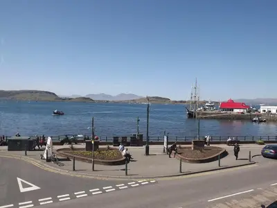 people walking on a sidewalk next to a body of water at Palace Hotel - Small Hotel in Oban