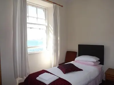 a small bedroom with a bed and a window at Palace Hotel - Small Hotel in Oban