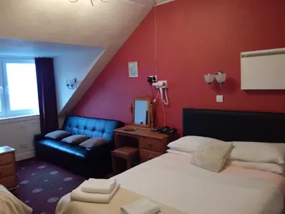 a hotel room with a bed and a couch at Palace Hotel - Small Hotel in Oban