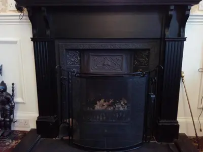 an old black fireplace in a living room at Palace Hotel - Small Hotel in Oban