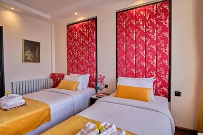 two beds in a room with red curtains at Muthu Oban Regent Hotel in Oban