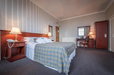 a hotel room with a bed and a desk with a phone at The Royal Hotel in Oban