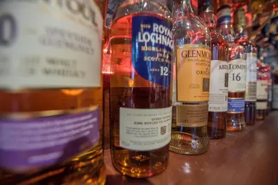 a row of bottles of alcohol sitting on a table at The Royal Hotel in Oban