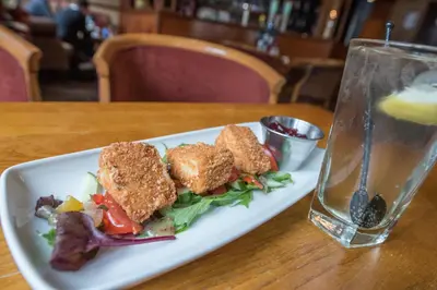 a plate of food on a table next to a glass at The Royal Hotel in Oban