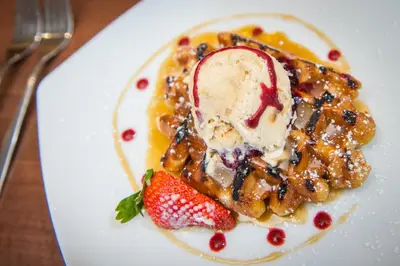 a white plate with a dessert with ice cream and strawberries at The Royal Hotel in Oban