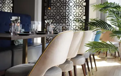 a dining room with a table with white chairs at The Perle Oban Hotel & Spa in Oban
