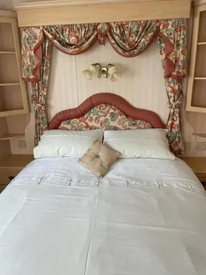 a large white bed in a bedroom with a headboard at The Lambourne 71 in Dunoon