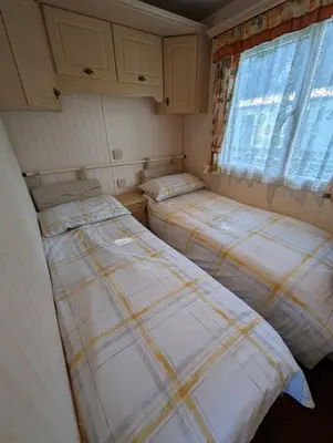 two beds in a small room with a window at The Lambourne 71 in Dunoon
