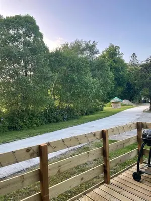 a wooden fence on a deck with a road at 55 Glenfinart Caravan Park in Dunoon