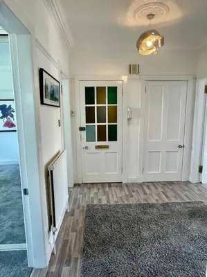 a room with a hallway with a door and a rug at Large 2 bed near Glasgow Airport in Paisley