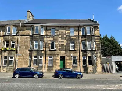 two cars parked in front of a brick building at Large 2 bed near Glasgow Airport in Paisley