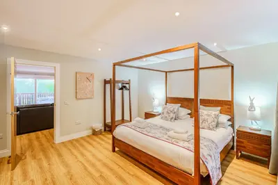 a bedroom with a four poster bed in it at Peregrine Cottage with Hot Tub in Newton Stewart