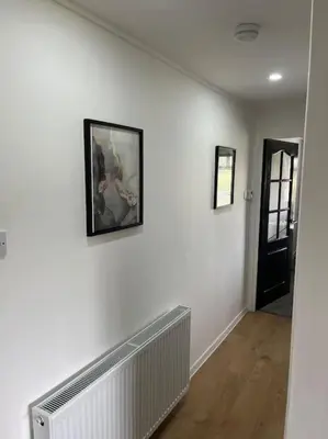 a hallway with a white wall with a picture on it at Erskine Apartment in Erskine