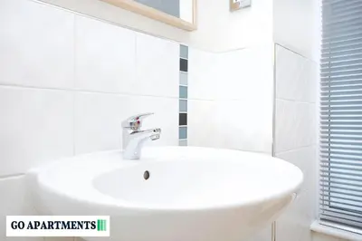 a white sink in a white bathroom with a window at Large 2 Bed Edinburgh City Centre Apartment - FREE Parking in Edinburgh
