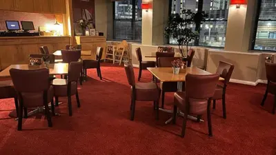 a restaurant with tables and chairs on a red carpet at Britannia Inn Glasgow in Glasgow