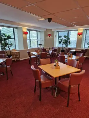 a dining room with tables and chairs and windows at Britannia Inn Glasgow in Glasgow