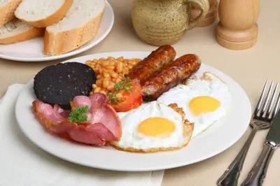 a plate of breakfast food with eggs bacon beans and bread at Britannia Inn Glasgow in Glasgow