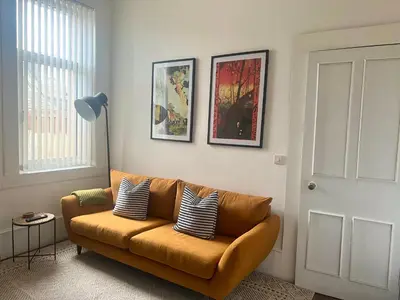 a living room with a brown couch with pillows on it at Spacious 3 Bedroom Home In Glasgow - Free Parking in Glasgow