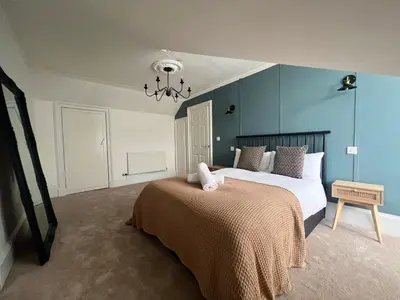 a bedroom with a large bed and blue walls at Spacious 3 Bedroom Home In Glasgow - Free Parking in Glasgow