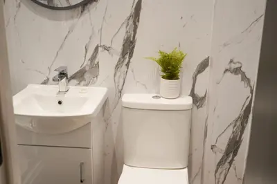 a bathroom with a sink and a toilet with a plant on it at Novana Aparthotel in Glasgow
