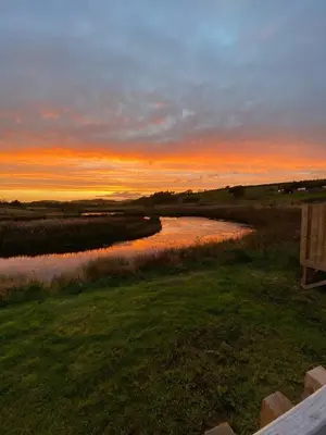 a view of a river at sunset with a bench at Pond View Pod 2 with Private Hot Tub - Fife - Loch Leven - Lomond Hills in Kelty