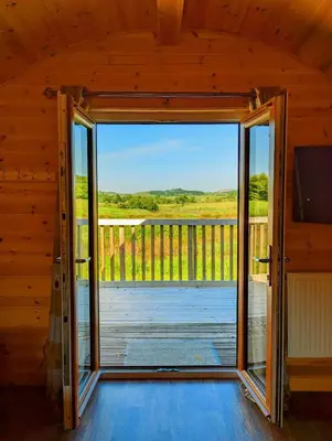 an open door in a cabin with a view of a deck at Pond View Pod 3 With Private Hot Tub -Fife - Loch Leven - Lomond Hills in Kelty