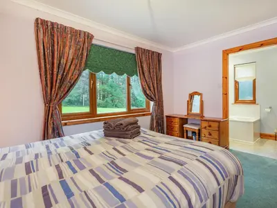 a bedroom with a large bed and a window at Bidean Lodge in Glencoe