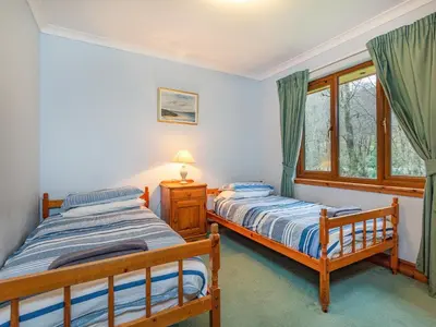 two twin beds in a room with a window at Bidean Lodge in Glencoe