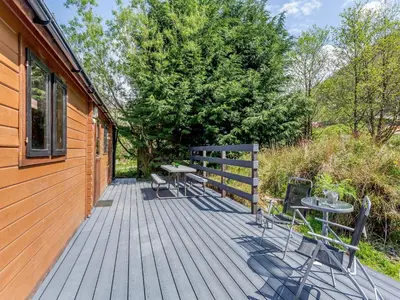 a wooden deck with a table and chairs on it at The Willows in Glencoe
