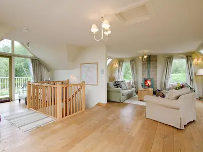 a living room with a couch and a staircase at Carness West in North Ballachulish