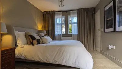 a bedroom with a bed with white sheets and a window at The Posting House in Kilchrenan