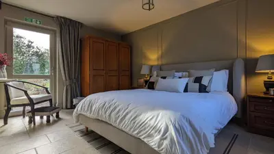 a bedroom with a bed and a chair and a window at The Posting House in Kilchrenan