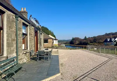 a patio with a table and chairs on a building at Cairnbaan House in Cairnbaan