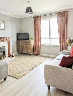 a living room with a couch and a television at Campbeltown View in Campbeltown