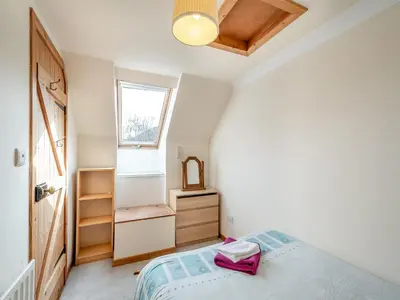 a small bedroom with a bed and a window at Stonefield Farm Cottage in Benmore