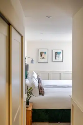 a bedroom with a bed with white sheets and pillows at Grove House Hotel in Edinburgh