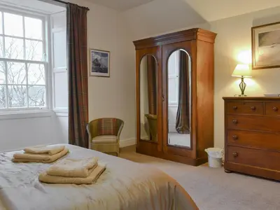 a bedroom with a bed and a dresser and a mirror at The Factors House - 25752 in Kilmartin