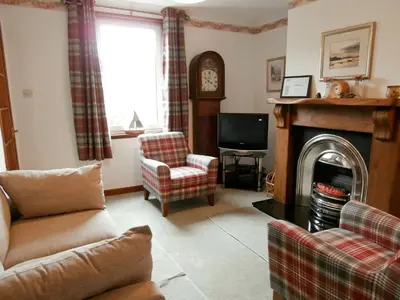 a living room with a couch and a fireplace at 15 Cairnbaan Cottage in Cairnbaan