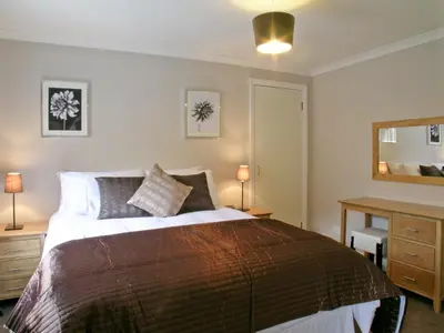 a bedroom with a bed and a desk and a mirror at Kerrera View in Oban