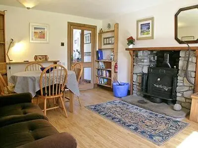 a living room with a table and a fireplace at Dalvuie Beag in Connel