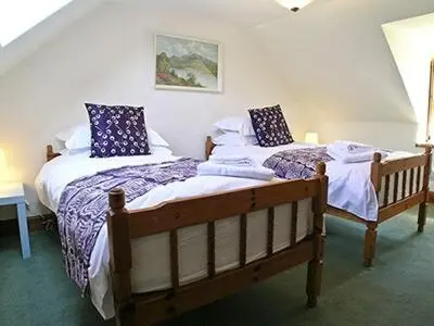 two twin beds in a room with at Dalvuie Beag in Connel