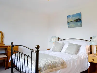 a bedroom with a bed and a desk with two lamps at Lunga - 28791 in Clachan