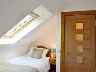 a bedroom with a bed next to a door at Lunga - 28791 in Clachan