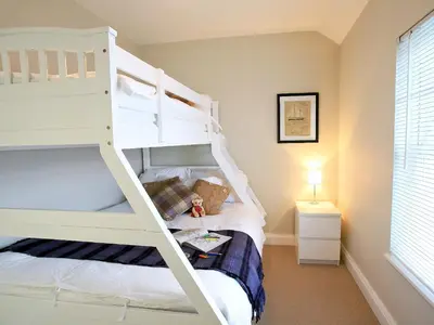 a bedroom with two bunk beds and a window at Ardbhan Croft in Oban