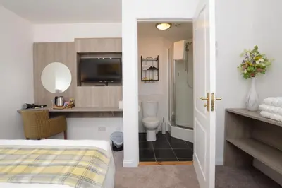 a hotel room with a bed and a bathroom at Fyne Rooms in Tighnabruaich