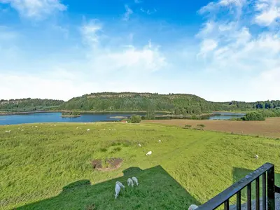 two white animals grazing in a field next to a lake at Kestrel Cottage - 27937 in Stirling